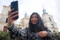 Travel selfie - young happy and beautiful Asian Korean tourist woman taking self portrait with mobile phone smiling in front of Royalty Free Stock Photo