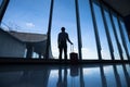 Travel, silhouette of passenger in airport, man with luggage waiting for the flight Royalty Free Stock Photo