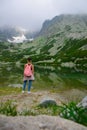 Travel Slovakia. Teenager girl tourist looking at wonderful mountain lake scenery back view