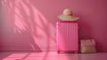 Travel in Style: Elegant Pink Suitcase and Hat on a Matching Pink Background Royalty Free Stock Photo
