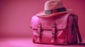Travel in Style: Elegant Pink Suitcase and Hat on a Matching Pink Background Royalty Free Stock Photo