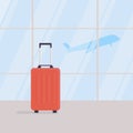 Travel suitcase in empty waiting area of airport terminal, against background of large windows, take-off of plane in background Royalty Free Stock Photo