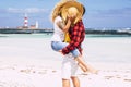 Travel and summer people holiday vacation couple hidden by straw hat kissing and enjoying romantic love relationship together at Royalty Free Stock Photo