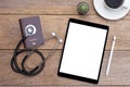 Travel insurance concept. Mockup image of Black digital tablet, passport, medical stethoscope Royalty Free Stock Photo