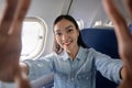 Travel and technology. Young woman asian in plane taking selfie while sitting in airplane seat