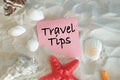 Travel tips - beach utensils with text on a piece of paper sandy beach background - recommendations for summer holidays. Royalty Free Stock Photo