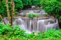 Travel to the beautiful waterfall in tropical rain forest, soft water of the stream in the natural park at Kanchanaburi, Thailand Royalty Free Stock Photo