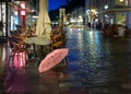 Travel to Europe Street cafe pink umbrella on old pavement  rainy evening city light    blurring bokeh effect background Royalty Free Stock Photo