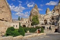 Travel to fairy Cappadocia. Street with restaurants and cave hotels carved inside stone rock at sunny day in old town Goreme.