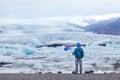 Travel to Iceland, tourist in Jokulsarlon glacier lagoon holding icelandic flag Royalty Free Stock Photo