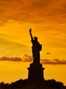 Travel to Manhattan, visit New York. Amazing summer sunset over Statue of Liberty with spectacular dramatic sky.