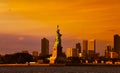 Travel to Manhattan, visit New York. Amazing summer sunset over Statue of Liberty with spectacular dramatic sky. Royalty Free Stock Photo