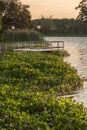 Travel to a portion of river with a natural scenery of sunset over a dock with lights Royalty Free Stock Photo