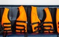 Travel to The Sea Safety. Group of Orange Life Vests on Blue Seat in Speed Boat for Tourist to use When Snorkeling in Ocean Royalty Free Stock Photo