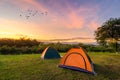 Travel to spread the tent in a wide open space in the evening. The golden sky mountain views on the Nakhasat Sabai In Chiang Mai