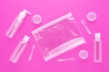 Travel toiletries, small plastic bottles for hygiene products on pink background