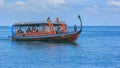 Travel tour for small group of foreign tourists with guide on traditional long tail boat ship visiting for snorkeling,diving