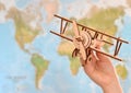 Travel and tourism concept. hand holding toy airplane against map of world Royalty Free Stock Photo