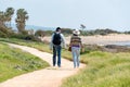 Travel and tourism. Mature family couple enjoying view together walking along the seashore, view from the back Royalty Free Stock Photo