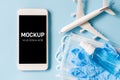 Travel and Tourism Planning after Quarantine. Mock up of smartphone with airplane model, face mask and sanitizer Royalty Free Stock Photo