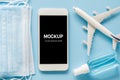 Travel and Tourism Planning after Quarantine. Mock up of smartphone with airplane model, face mask and sanitizer Royalty Free Stock Photo