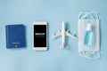 Travel and Tourism Planning after Quarantine. Smartphone with airplane model, passports, face mask and sanitizer Royalty Free Stock Photo