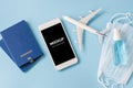 Travel and Tourism Planning after Quarantine. Smartphone with airplane model, passports, face mask and sanitizer Royalty Free Stock Photo