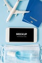 Travel and Tourism Planning after Quarantine. Smartphone with airplane model, passports, face mask and sanitizer Royalty Free Stock Photo