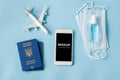 Travel and Tourism Planning after Quarantine. Smartphone with airplane model, passports, face mask and sanitizer Royalty Free Stock Photo