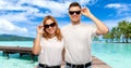 Happy couple in t-shirts and sunglasses on beach Royalty Free Stock Photo