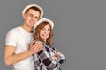 Travel and Tourism. Young couple in hats standing hugging isolated on grey smiling joyful team spirit