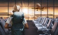 Travel tourist standing with backpack watching sunset at airport window. Passenger seat in departure lounge for see airplane, View Royalty Free Stock Photo