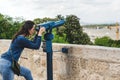 Travel tourist woman on Europe holidays. Hipster girl using telescope looks panorama of the city. Travelling, leisure, recreation Royalty Free Stock Photo