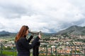 Travel tourist woman on Europe holidays. Hipster girl using telescope looks panorama of the city. Travelling, leisure, recreation Royalty Free Stock Photo