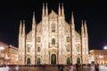 Travel tourist woman feeds doves near Duomo di Milano - the cathedral church of Milan in Italy. Girl enjoying on the square in the Royalty Free Stock Photo