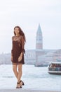 Travel tourist woman on pier against beautiful view on venetian chanal in Venice, Italy. Royalty Free Stock Photo