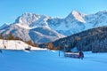 Red train in snow-covered Alpine scenery by blue sky Royalty Free Stock Photo