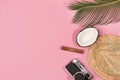 Travel vacation background concept. Coconut, hat, camera, palm leaves on pink background Royalty Free Stock Photo