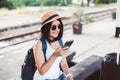 Travel and vacation concept,Happy asian woman tourist using cell phone and waiting train at train station