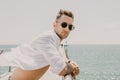 Travel vacation holiday concept.Handsome happy man wearing white shirt and sunglasses at the sea or the ocean background. Royalty Free Stock Photo