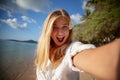 Travel vacation tourist blonde teen girl selfie photo with phone on tropical holiday Royalty Free Stock Photo