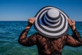 Travel vacation woman on holiday in sunhat enjoying looking view of ocean on hot summer day Royalty Free Stock Photo