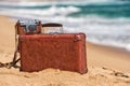 Travel vintage suitcase and camera on a beach Royalty Free Stock Photo