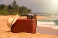 Travel vintage suitcase and camera on a beach Royalty Free Stock Photo