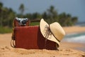 Travel vintage suitcase and camera on a beach Royalty Free Stock Photo