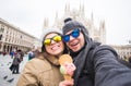 Travel in winter and Italy concept - Happy young couple take selfie photo with ice-cream in front of Milan Duomo Royalty Free Stock Photo