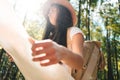 Travel woman reading map among trees at forest and searching directional for travling with a backpack Royalty Free Stock Photo