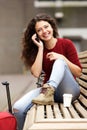 Travel woman sitting outside and taking on cell phone Royalty Free Stock Photo
