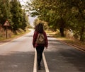 Travel, woman and walking with backpack on road in the countryside for hiking or journey in Ukraine. Back, girl or Royalty Free Stock Photo