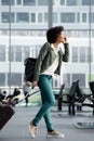 Travel woman walking and talking at station with mobile phone and suitcase Royalty Free Stock Photo